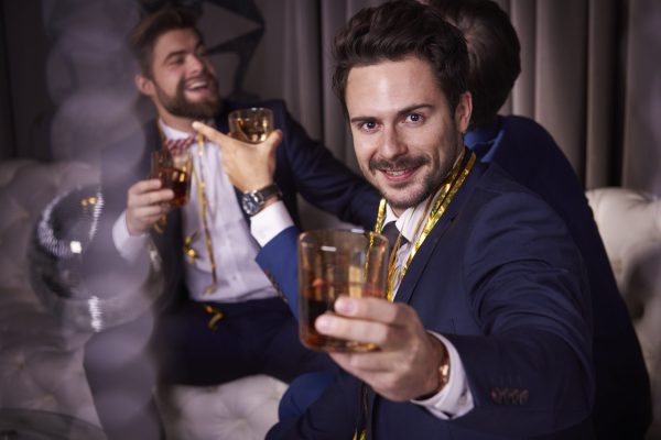 Group of businessmen with whiskey enjoying at night club Group of businessmen with whiskey enjoying at night club