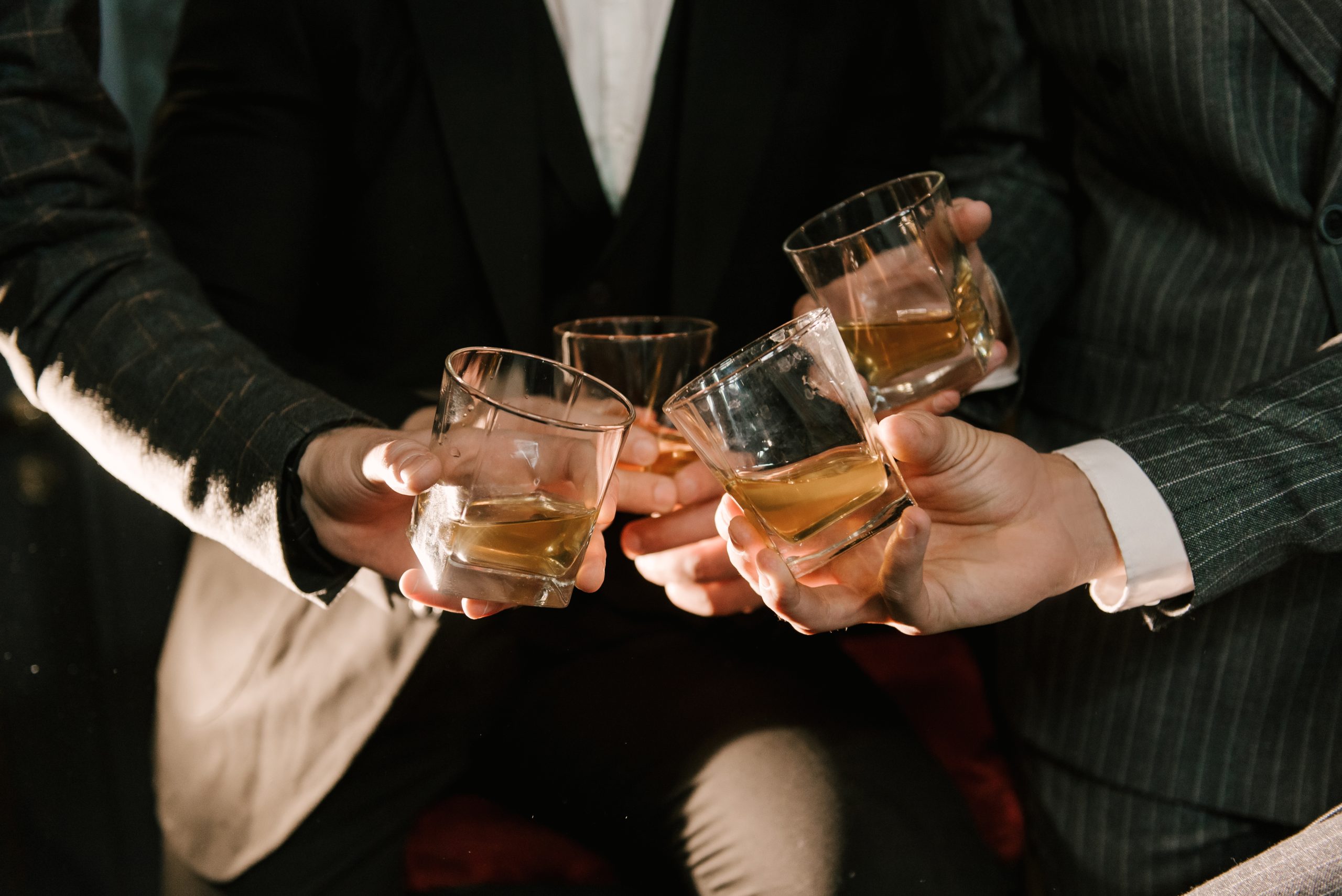 Men's hands with glasses of whiskey barbershop