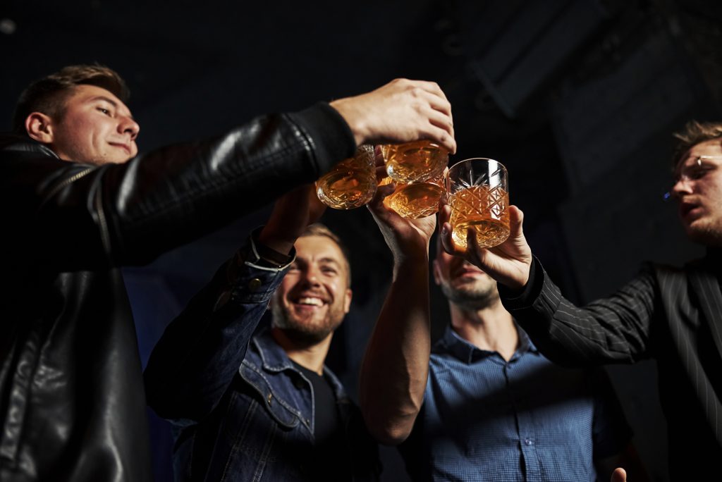 Weekend time spending. People have fun in the club. With alcohol in hands