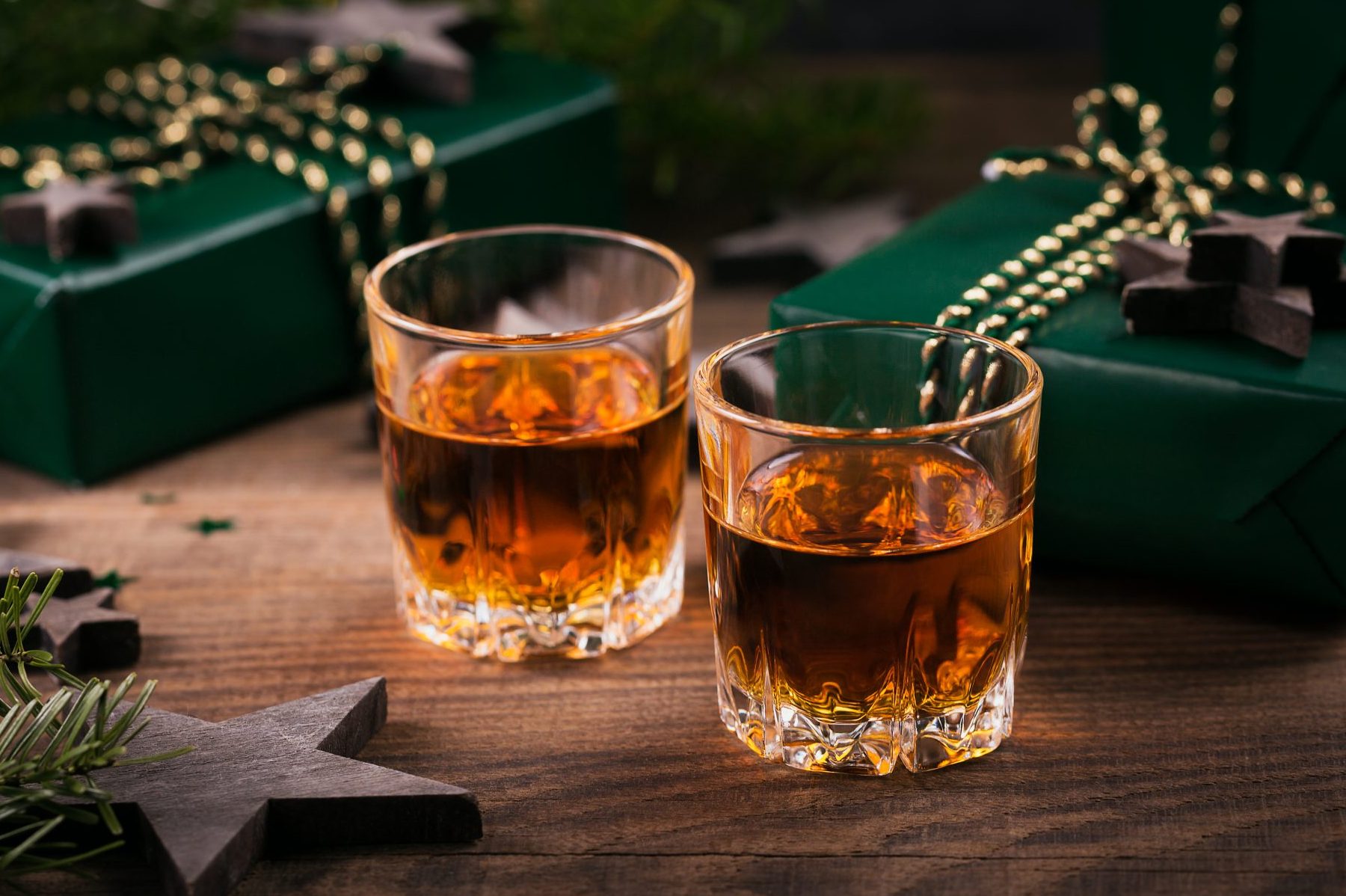 Two shot glasses of whiskey or bourbon with Holiday decoration